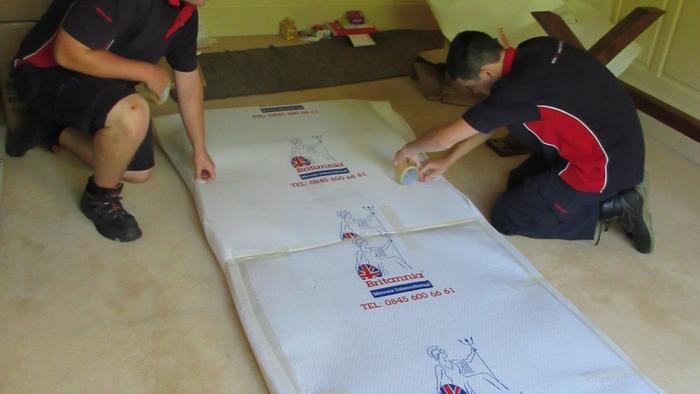 Removal men Wrapping a Dining table top.